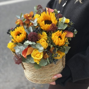 Композиция в сумке "Тональность" из подсолнухов, калл, ягод вибирнума, лимонных роз, скиммии и орхидеи в Ликино-Дулёво